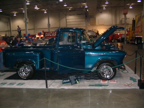 1993 Ford Taurus - A teal 1956 pickup truck is displayed indoors with its hood open.