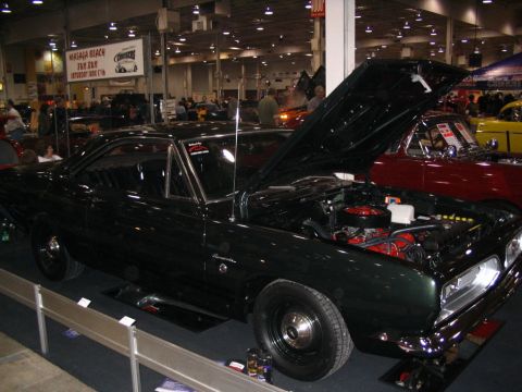 1993 Ford Taurus - A dark green coupe, likely a 1967 model, is displayed with its hood open at a car show.