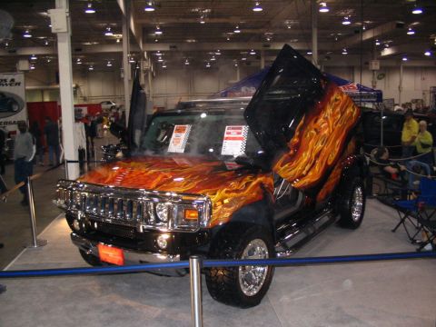 1993 Ford Taurus - This SUV features custom flame paint and unique scissor doors, displayed at an indoor event.