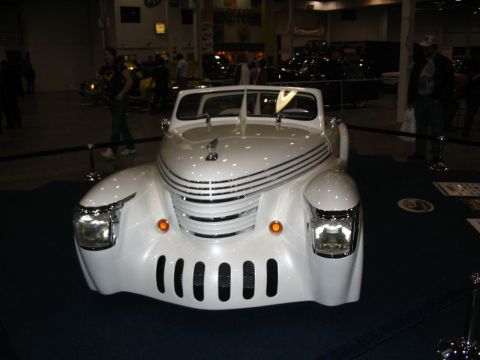 1993 Ford Taurus - A custom hot rod with a distinctive chrome grille and vertical slots is displayed indoors.