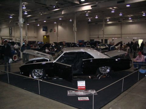1993 Ford Taurus - A customized classic car is showcased at an indoor event with its doors, hood, and trunk open.