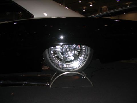 1993 Ford Taurus - Customized car with elaborate chrome wheels and large brake rotors is displayed indoors.