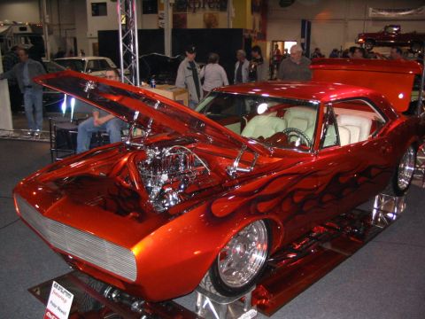 1993 Ford Taurus - Customized classic car with flame paint and exposed engine on display.