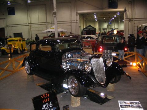 1993 Ford Taurus - A black 1931 Ford hot rod with a prominent chrome engine is displayed indoors.