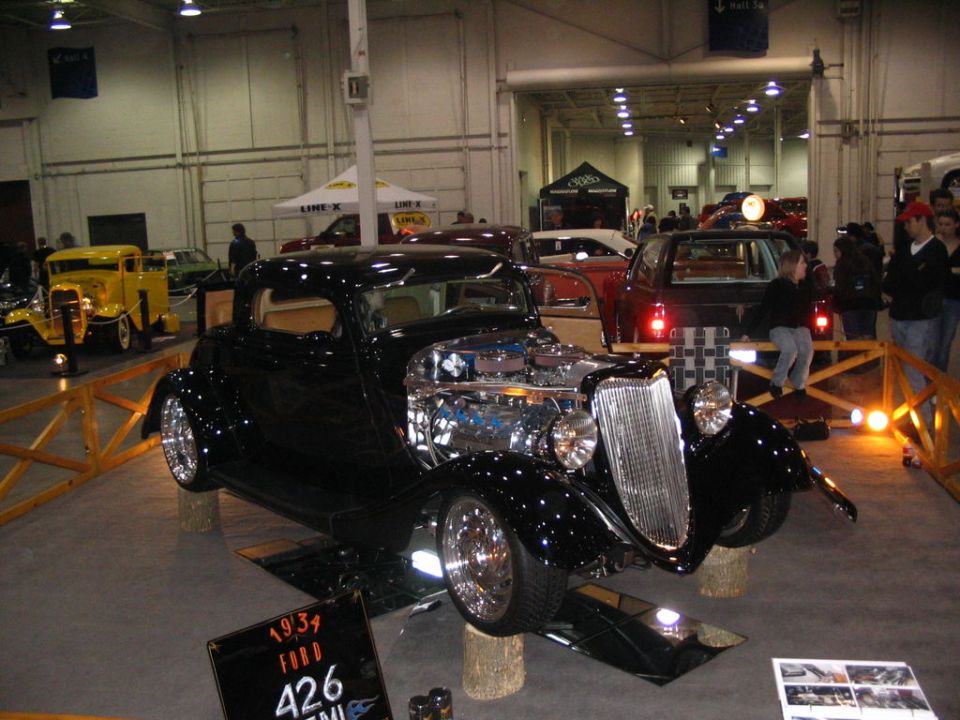 Black 1931 Ford hot rod with exposed chrome engine, on display