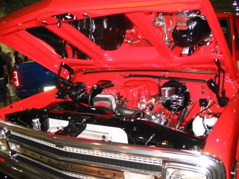 1993 Ford Taurus - The open hood reveals a detailed engine bay with a blue truck visible behind it.