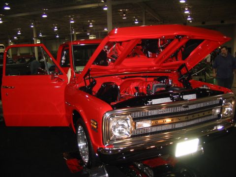 1993 Ford Taurus - This red Chevrolet pickup truck, likely from 1971, is displayed with its hood and driver's door open, revealing the engine bay.