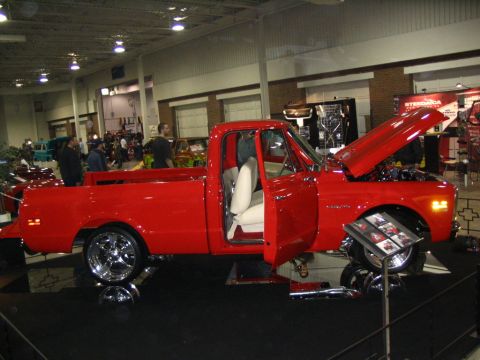 1993 Ford Taurus - Custom red pickup truck on display at a show, a clean white interior and open engine bay.