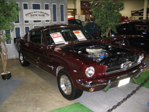 1993 Ford Taurus - This maroon 1965 Ford Mustang coupe is displayed with its hood open, revealing the engine bay.