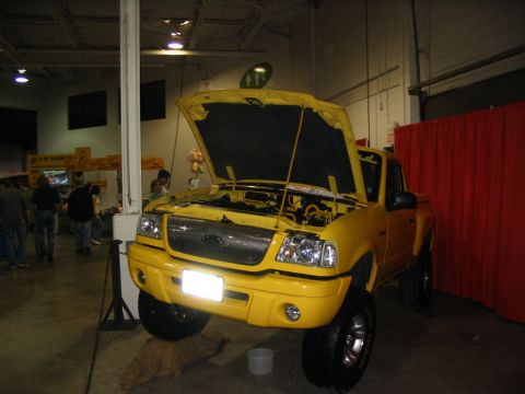 1993 Ford Taurus - This yellow Ford Ranger pickup truck is displayed with its hood open, revealing the engine compartment.