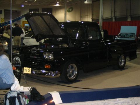 1993 Ford Taurus - This black 1958 GMC pickup truck is displayed with its hood open, revealing the engine bay.