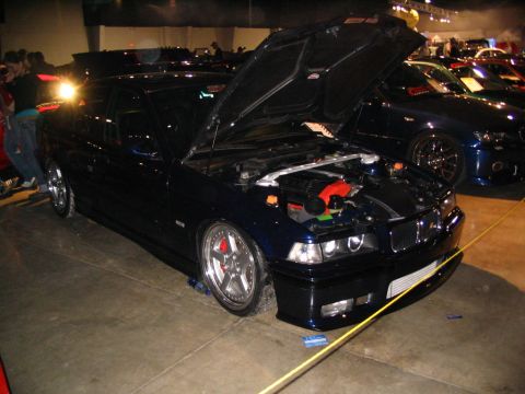 1993 Ford Taurus - Dark blue BMW E36 coupe on display with hood open, revealing the engine bay.