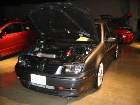 1993 Ford Taurus - Front view of a modified Volkswagen Jetta with its hood open, parked indoors.