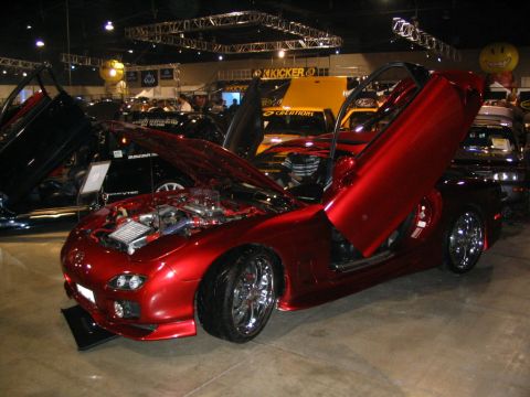 1993 Ford Taurus - Customized red Mazda RX-7 displayed indoors with its doors and hood open.