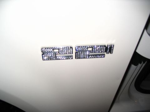 1993 Ford Taurus - Close-up of a rhinestone emblem attached to the side of a white vehicle.
