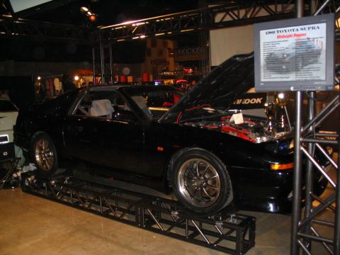 1993 Ford Taurus - A black 1989 Toyota Supra is displayed with its hood open, revealing the engine bay.