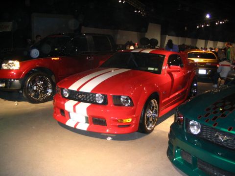 1993 Ford Taurus - Several custom vehicles are displayed indoors, including a red Mustang with racing stripes.