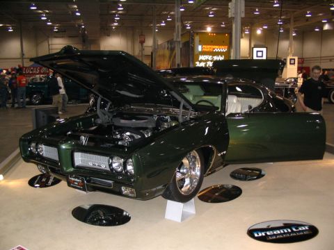 1993 Ford Taurus - A custom green 1969 Pontiac GTO is displayed with its hood and driver's door open, revealing the engine and interior.