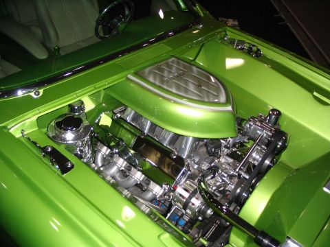 1993 Ford Taurus - The engine bay of a custom car features a polished V8 engine with chrome components and a bright green paint job.