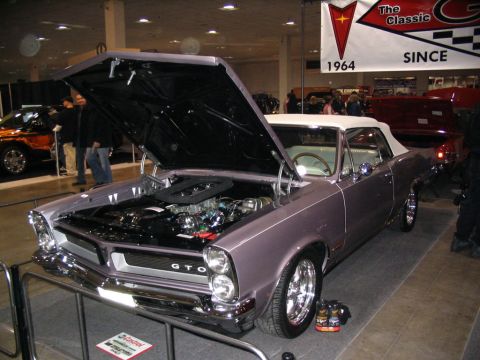 1993 Ford Taurus - A classic 1964 Pontiac GTO convertible is displayed with its hood open, revealing the engine.