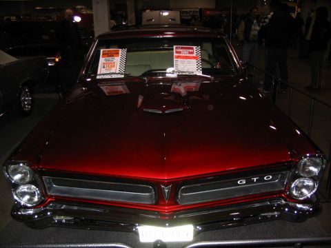 1993 Ford Taurus - This classic red 1965 Pontiac GTO is displayed at a car show, its iconic front grille and badging.