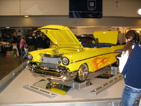 1993 Ford Taurus - A bright yellow convertible, likely a 1957 model, is displayed with its hood and trunk open, flame decals and custom wheels.