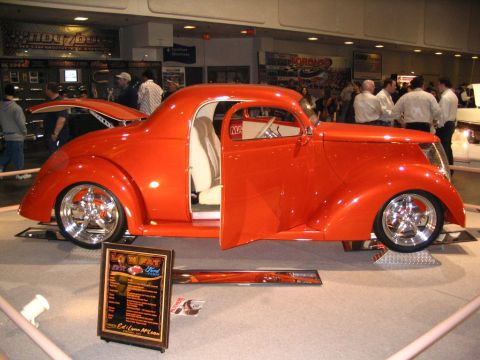 1993 Ford Taurus - Custom 1937 Ford coupe on display at a show, a bright orange paint job and open doors.
