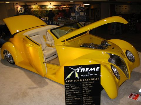 1993 Ford Taurus - A bright yellow custom hot rod convertible is displayed with its hood and doors open, revealing its interior and engine details.