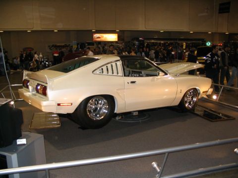 1993 Ford Taurus - This modified 1975 Ford Mustang II coupe is displayed indoors with its hood up and custom wheels.