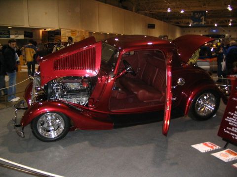 1993 Ford Taurus - A custom hot rod coupe with its hood and door open is displayed indoors.