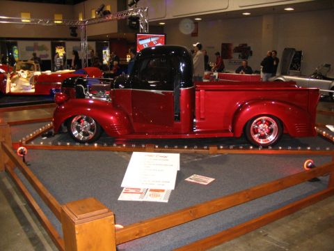 1993 Ford Taurus - Customized red and black pickup truck on display at an event. The truck features a two-tone paint scheme and custom wheels.