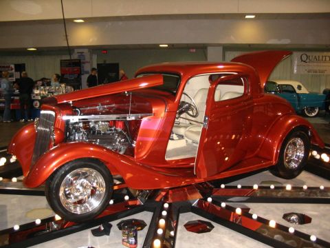 1993 Ford Taurus - A custom hot rod coupe is displayed with its hood and door open, revealing its engine and interior.