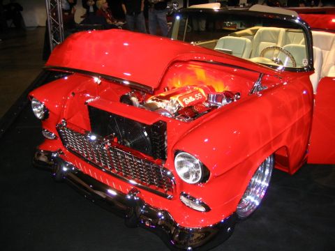 1993 Ford Taurus - A red 1955 Chevrolet Bel Air convertible is displayed with its hood open, revealing a customized engine.