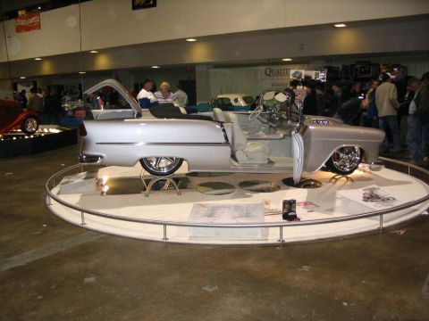 1993 Ford Taurus - A customized silver convertible with a white interior is showcased at an event.
