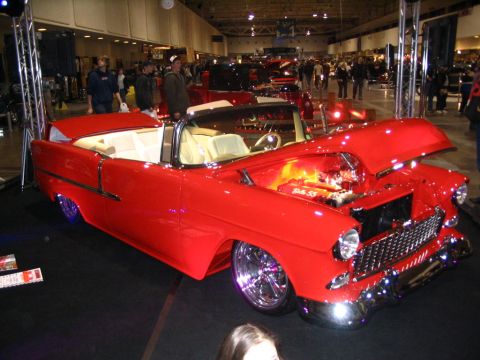 1993 Ford Taurus - A red 1955 Chevrolet Bel Air convertible is displayed with its hood open, revealing a custom engine.
