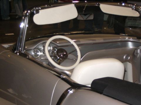 1993 Ford Taurus - The interior of a classic convertible shows off its white steering wheel and seats against a silver dashboard.