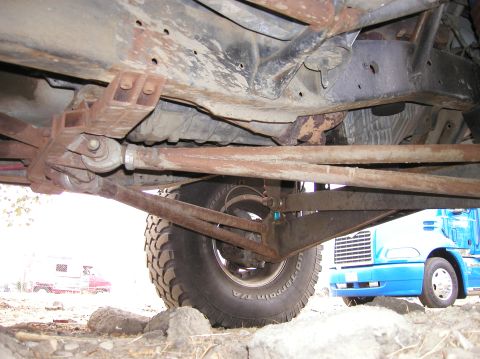 1984 Ford Bronco - The underside of a vehicle is shown, with a blue semi-truck visible in the background.