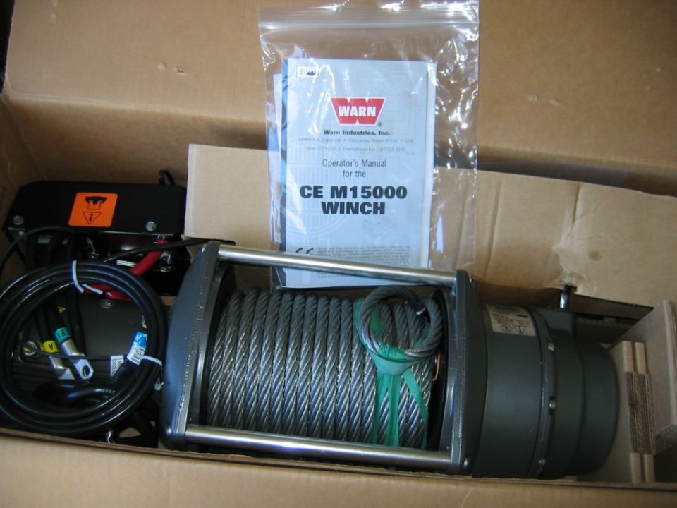 Warn CE M15000 winch with steel cable, and operator's manual in plastic bag, inside a cardboard box