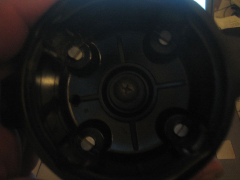 Interior of a black distributor cap with four screw terminals