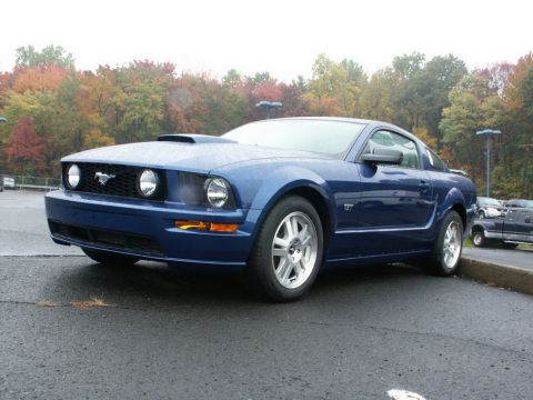 2001 Mercury Grand Marquis - Blue Ford Mustang with a hood scoop and GT badging.