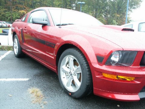 2001 Mercury Grand Marquis - A red 2005 Ford Mustang GT/CS is parked in a lot on a rainy day.