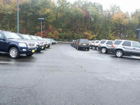 2001 Mercury Grand Marquis - Multiple Ford Explorer SUVs are parked in a lot on a cloudy day.