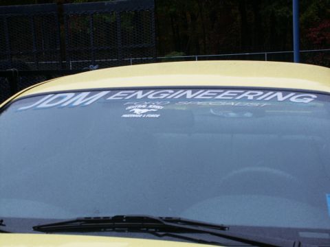 2001 Mercury Grand Marquis - A yellow car's windshield displays "JDM ENGINEERING" and "FORD SPECIALIST" decals.