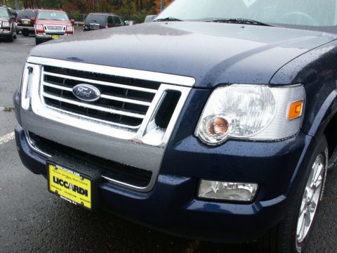 2001 Mercury Grand Marquis - Front view of a dark blue Ford Explorer, its distinctive grille and headlights. Other vehicles are visible in the background.