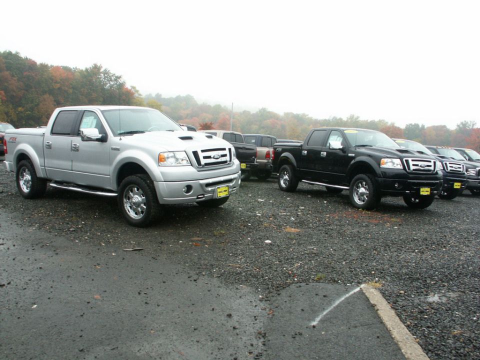 Silver and black Ford F-150 trucks parked on a lot