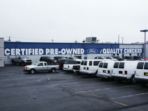 2001 Mercury Grand Marquis - A variety of Ford trucks and vans are parked in the lot of a certified pre-owned dealership.