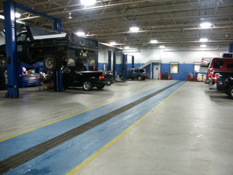 2001 Mercury Grand Marquis - Multiple vehicles are present in a service bay, with some on lifts and others parked in the bay.