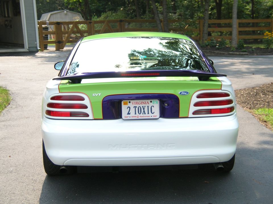White Ford Mustang with green and purple accents on the rear, custom paint job