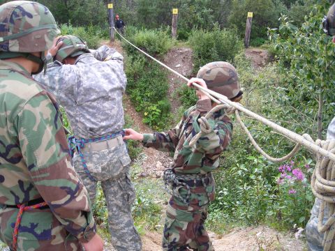 2003 Jeep TJ - Military personnel engage in a rope training exercise on an outdoor course, focusing on teamwork and safety procedures.