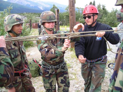 2003 Jeep TJ - Military personnel train in knot tying techniques outdoors, with a mountainous landscape visible.
